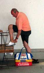 Aliventi Luerano prepares for play by trading his sandals for Bocce shoes.