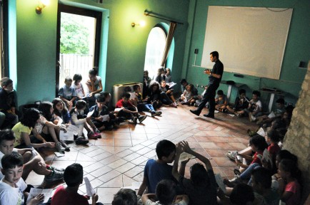 Children listen to Father Diego Fascinetti during summer camp.