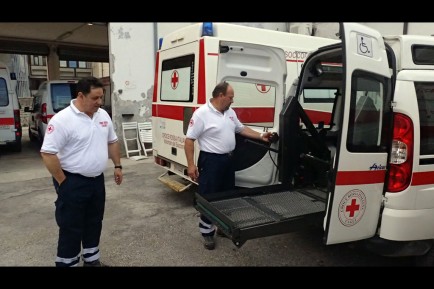 Filippo Torri and Marco Pedando demonstrate the ramp used to transport wheelchair patients.