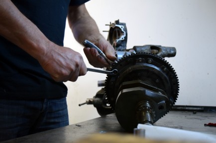 With wrenches in hand, Roberto disassembles a motorcycle engine.
