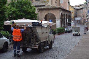Workers of Marche Multiservizi clean the streets of Urbino by disposing filled trash bins before the town awakens.