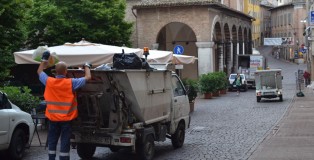 Workers of Marche Multiservizi clean the streets of Urbino by disposing filled trash bins before the town awakens.