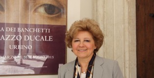 Maria Claudia Caldari poses in front of La Muta advertisement outside the Palazzo Ducale.