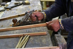 Domenico shaving a freshly cut piece of wood.