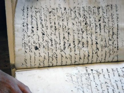 Giuseppe Aguzzi reveals quill written records from the Bishop's Archive. June 29, 2016 photo by Ellen Murphy/ Gonzaga in Cagli